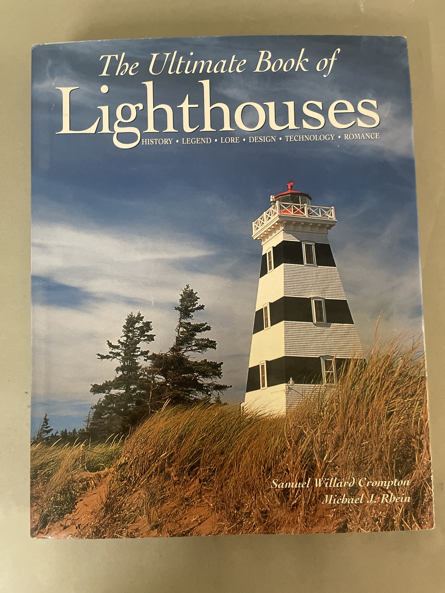Blue Hardcover Book titled The Ultimate Book of Lighthouses